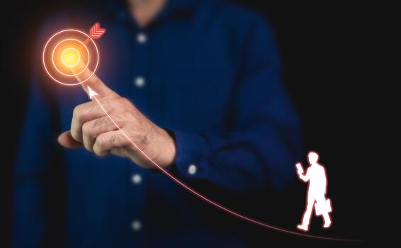 Heading towards business goals, the path to success, continuous development planning, and strategies, pointing finger at target icon to guide and a hologram of man icon walking on the marked path. photo