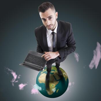 Businessman networking globally using laptop while standing on earth globe, aerial view photo