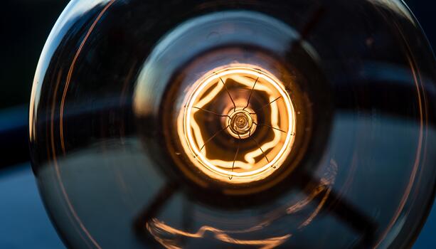 Close-up of Vintage Edison Light Bulb with Glowing Filament in Dark Setting photo