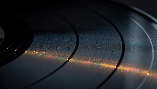 Close-up of a Vinyl Record with Colorful Reflections on Black Surface in Low Light photo