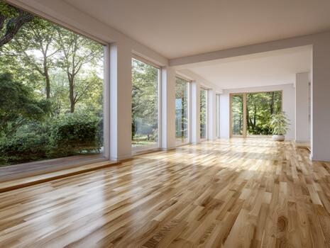 Sunny open space with wooden floors and large windows surrounded by nature photo