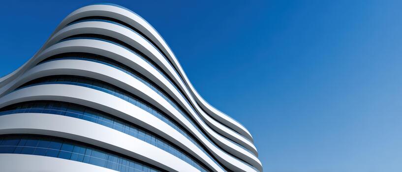 Modern curved architecture under a clear blue sky in a city setting photo