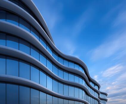 Modern wavy architecture reflecting blue sky in a city setting photo