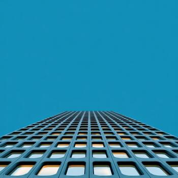 Vertical view of a modern building against a clear blue sky photo
