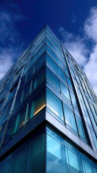 Modern glass building reaching towards the sky in an urban area photo