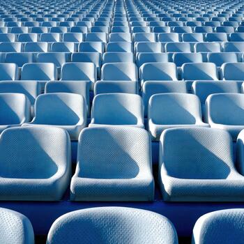 Empty stadium seats arranged in neat rows under bright sunlight photo