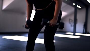 Building strength with dumbbells in a modern gym during a focused workout session in the evening video