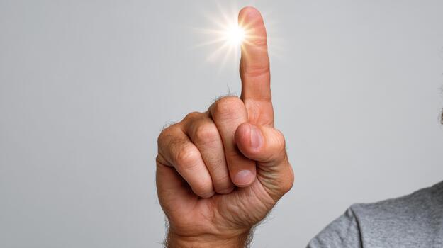 A close-up of a male hand, Caucasian, pointing upwards with a glowing light at the fingertip, symbolizing inspiration or a bright idea. photo
