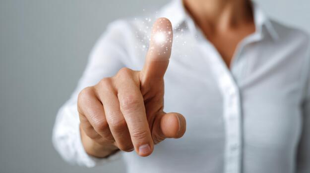 A close-up of a woman's hand extending a finger towards an ethereal light, embodying a sense of magic and possibility. photo