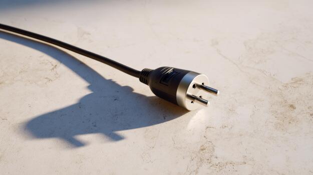 A close-up of a black electrical plug casting a shadow on a textured surface. photo