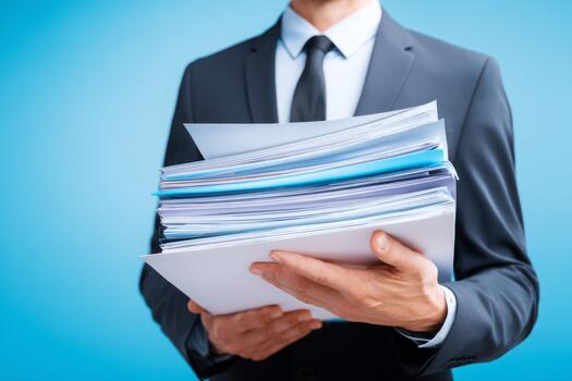 profesional hombre participación un grande apilar de documentos en un negocio ajuste con un azul antecedentes foto