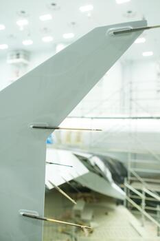 New aircraft component undergoes assembly process in high-tech workshop with bright overhead lights and advanced tools present photo