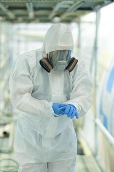 Worker in protective gear preparing for a task in a construction site environment with scaffolding and safety measures in place during daylight hours photo