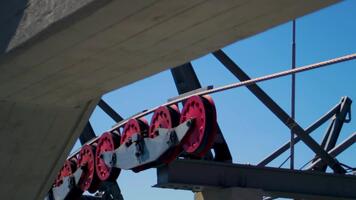 acciaio cavo si sposta attraverso puleggia, mostrando meccanico precisione e altitudine sostegno. supporto detiene struttura con durevole tensione. concetto di montagna la logistica come ingegnerizzato affidabilità. video