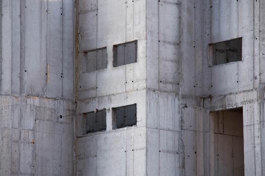 Exterior of Concrete Wall Frame of Building under Construction. Architectural origin of Structure. Monolithic box with holes for windows and floor slabs on sunny day at Construction Site. photo