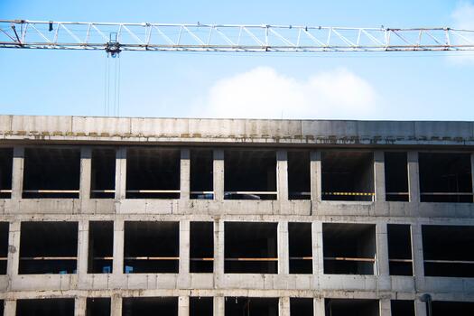 Front view Concrete Wall Frame of Building under Construction with Tower Crane Boom. Formwork Prints with wooden Fence. Monolithic box window holes Construction Site. Architectural origin Structure. photo