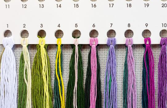 A chart with different colored threads hanging on it photo