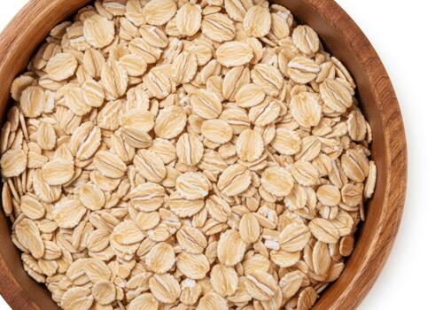 Close up of rolled oats in a wooden bowl isolated on white background photo