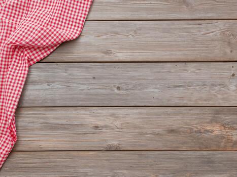 Red checkered tablecloth on a rustic wooden table. Top view background with copy space. photo