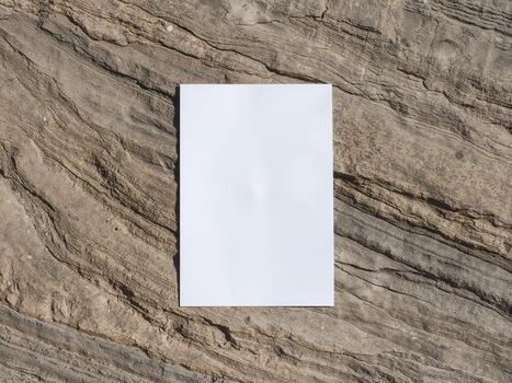 Blank vertical paper mockup on a rough rock texture. Empty A4 or A5 card on a natural stone background. photo
