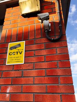 CCTV Sign and Surveillance Camera on Red Brick Wall in Manchester, United Kingdom photo