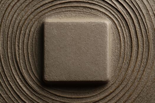 Stone placed on a smooth, circular pattern of sand reflecting tranquility and simplicity in a Zen garden setting photo