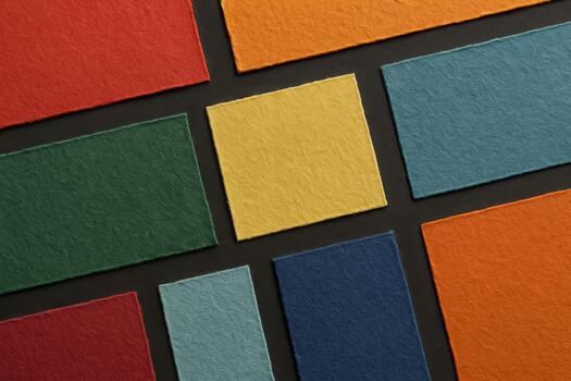 Colorful sheets of textured paper arranged in a grid for art and design projects in soft lighting photo