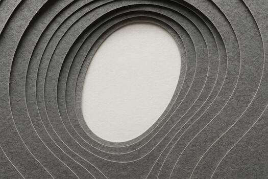 Layers of gray paper create a textured pattern with an oval cutout at the center, showcasing creativity in design and art photo