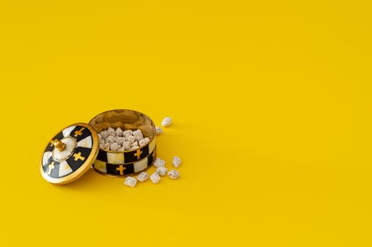 Orthodox incense box on bright yellow background. Minimal Orthodox Christian faith concept. Religious items with copy space for text. photo