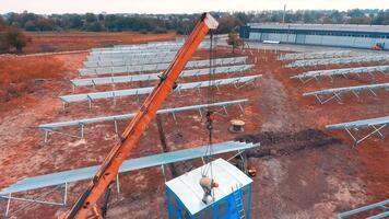 arbetstagare påfrestande till fästa de krokar från kran till de metall bås. cirkel rörelse runt om de område under konstruktion. topp se. video