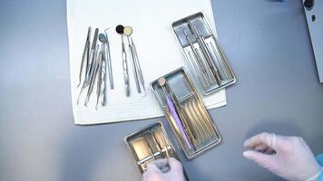 förberedelse av metall verktyg för dental vård kolla upp upp. sjuksköterska handskar händer ta de instrument från en tabell och dela upp dem in i flera brickor. stänga upp. topp se. video
