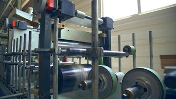 Wooden beam being processed at the modern factory. Automated line with multiple rollers move the balks along. video