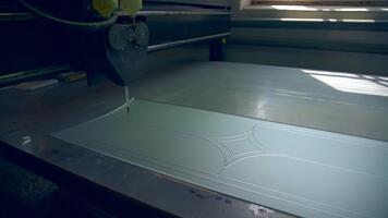 Piece of frosted glass is decorated with lines. Picture is applied on the future door by the automated tool machine. video