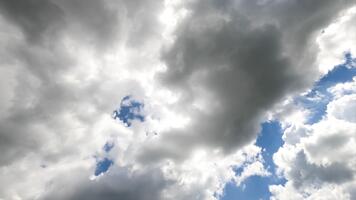White and grey clouds forming in the blue sky. Rays of sun breaking through the clouds timelapse. View from below. video