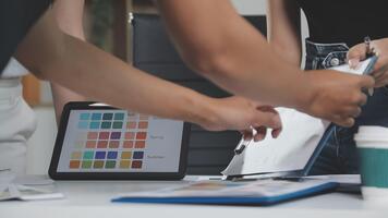 A group of people working on a computer with a tablet video