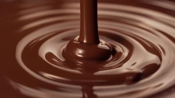 makro se av läcker smält mörk choklad varelse hällde, skapande silkig slät krusningar och vågor i en dekadent slå samman av konfektyr godhet video