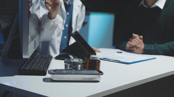 dos doctores hablando en un computadora en frente de un escritorio video