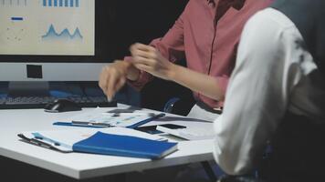 Two people working on a computer in front of a monitor video