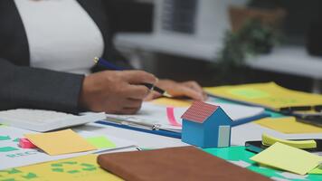 en person är arbetssätt på en projekt på en skrivbord med en massa av papper och klibbig anteckningar video