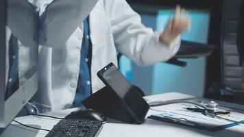 A doctor is working on a computer with a tablet video
