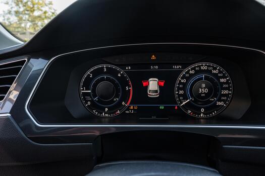 Dashboard display showing vehicle metrics and alerts during a daytime drive photo