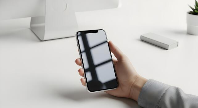 Modern Smartphone in Hand with Clean White Desk Setup for Technology Background photo