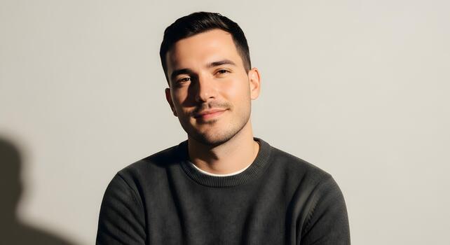 Portrait of a confident and attractive young man looking directly at the camera neutral backdrop photo