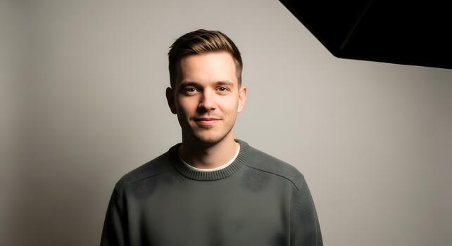 Portrait of a handsome young man with a friendly expression in studio lighting and natural hair photo