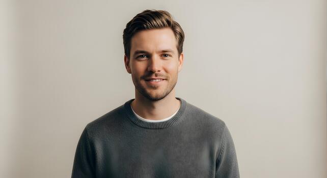Portrait of a young man with a friendly smile in a studio setting neutral background photo