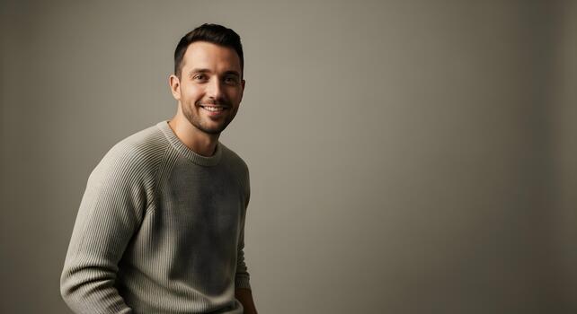 Portrait of handsome smiling man in studio setting with neutral background confident and friendly photo