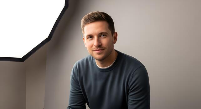 Professional headshot of a young man with a calm expression in a studio setting photo