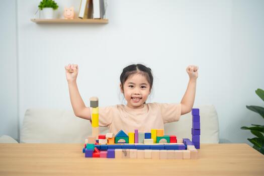 Joyful Child Celebrating Success with Colorful Building Blocks in a Bright and Inviting Indoor Space photo