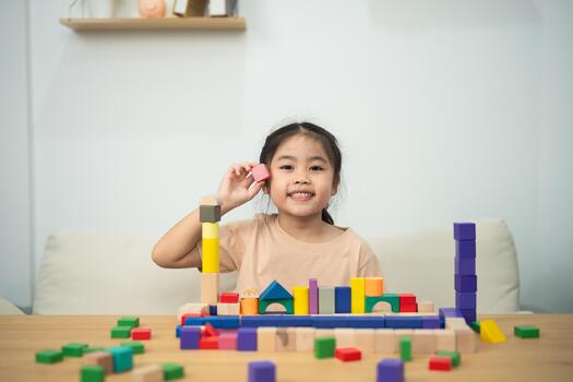 Smiling Girl Playing with Colorful Building Blocks at Home, Engaging in Creative Learning and Imaginative Play with Educational Toys photo
