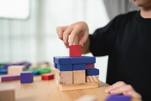 Child Engaged in Creative Play with Colorful Wooden Blocks Stacking and Building Skills in Bright and Inviting Indoor Environment photo